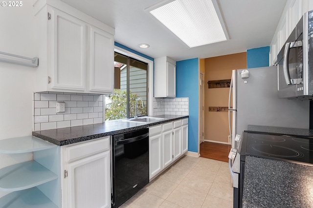 kitchen featuring black dishwasher, electric range oven, stainless steel microwave, white cabinets, and a sink