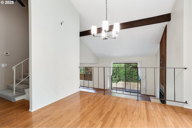 spare room with an inviting chandelier, beam ceiling, high vaulted ceiling, wood finished floors, and stairway