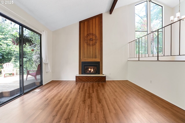 unfurnished living room featuring visible vents, a large fireplace, light wood-type flooring, baseboards, and lofted ceiling with beams