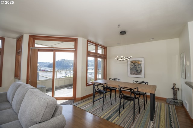 dining space featuring a mountain view, baseboards, and wood finished floors