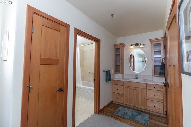 bathroom with vanity, shower / bathtub combination with curtain, and baseboards