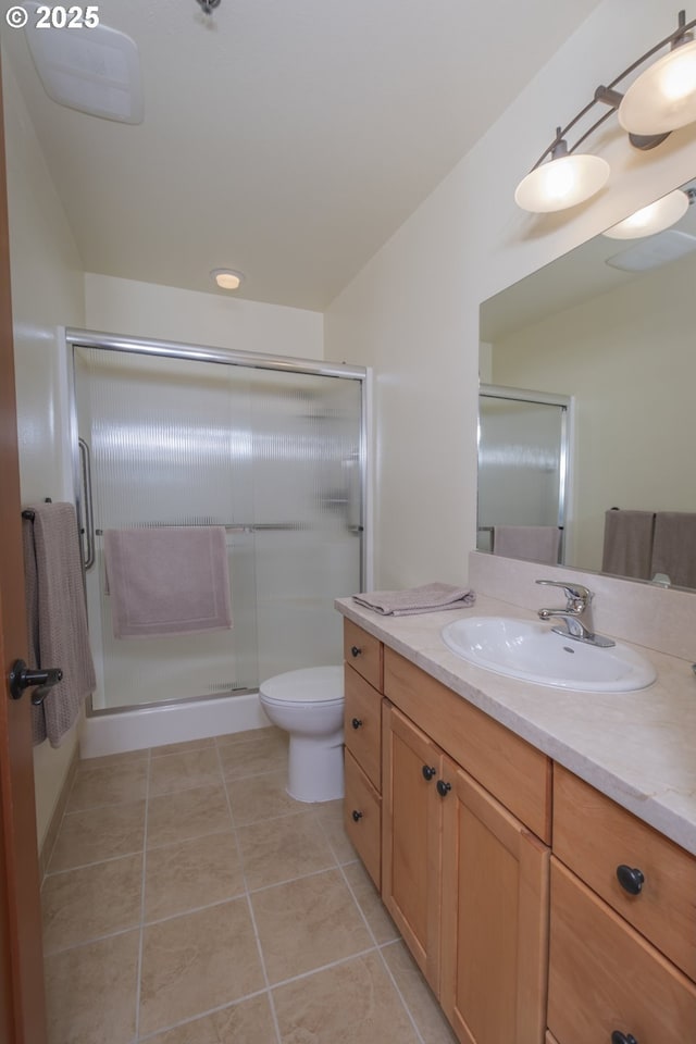 full bath with toilet, a stall shower, vanity, and tile patterned flooring