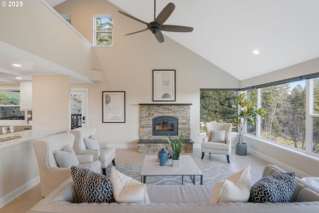 tiled living room featuring ceiling fan, a stone fireplace, high vaulted ceiling, and a wealth of natural light