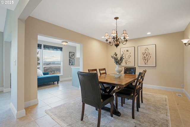 tiled dining space featuring a chandelier