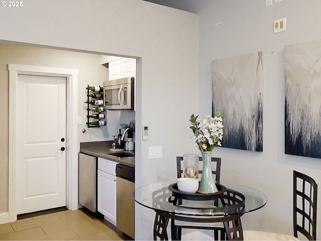 kitchen with stainless steel appliances, sink, and white cabinets