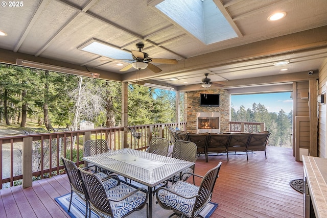 wooden terrace featuring ceiling fan and exterior fireplace