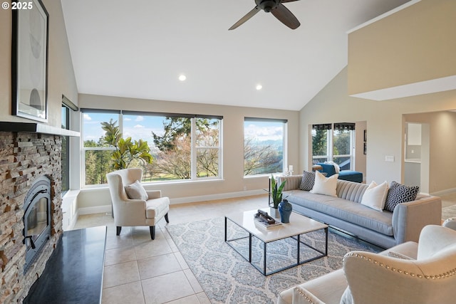 living room with ceiling fan, high vaulted ceiling, light tile patterned floors, and a fireplace