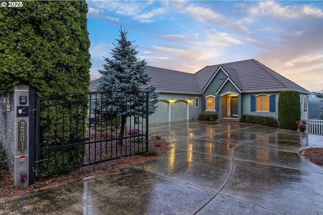 ranch-style house with a tile roof, an attached garage, concrete driveway, and fence