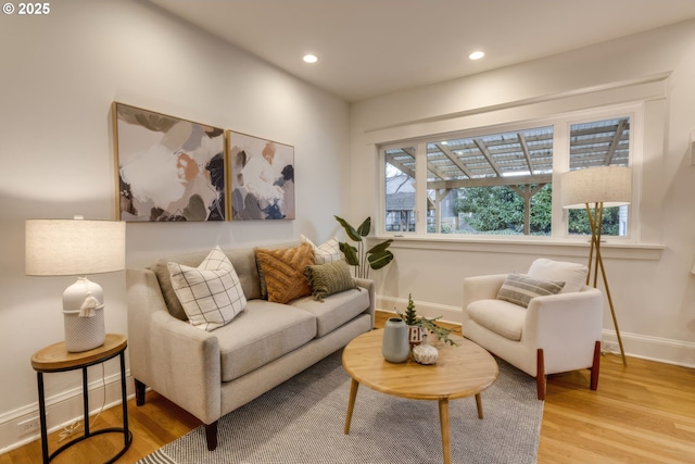 living area with recessed lighting, baseboards, and light wood finished floors