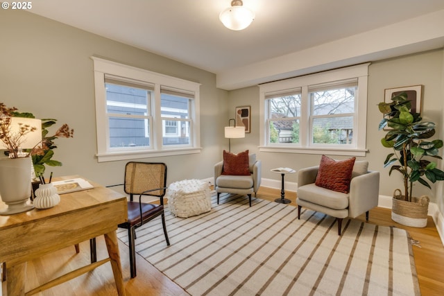 sitting room with baseboards and light wood finished floors