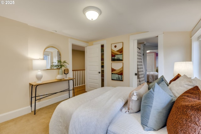 bedroom featuring baseboards and light carpet