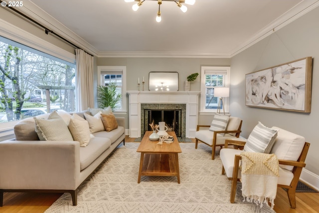 living room with a healthy amount of sunlight, ornamental molding, and light wood finished floors