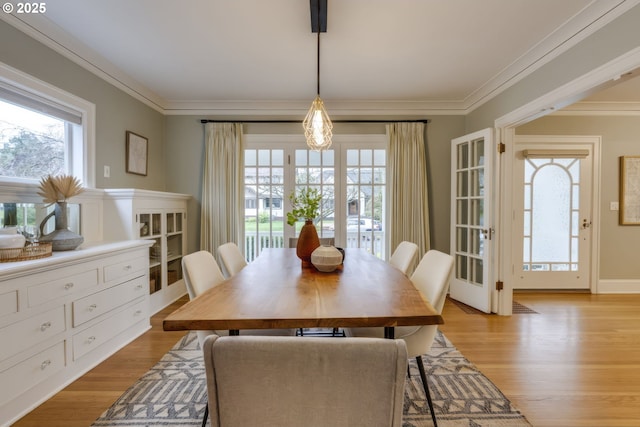 dining area with plenty of natural light, light wood-style floors, and ornamental molding