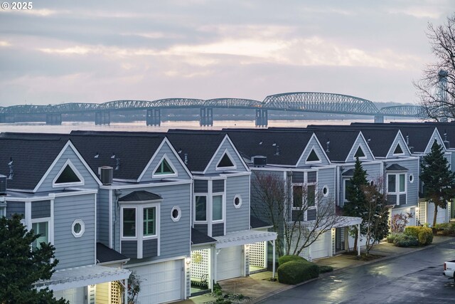 view of front of property featuring a garage and a water view