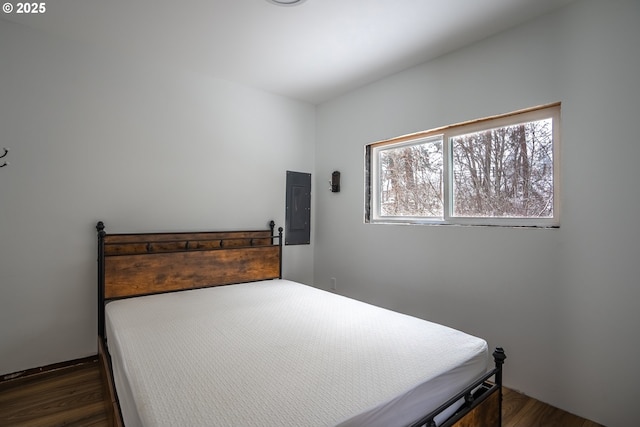 bedroom with electric panel and dark hardwood / wood-style flooring