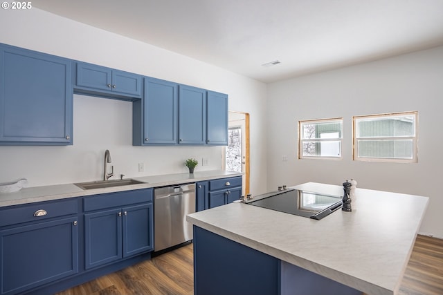 kitchen featuring dark wood-type flooring, blue cabinetry, stainless steel dishwasher, a center island, and sink