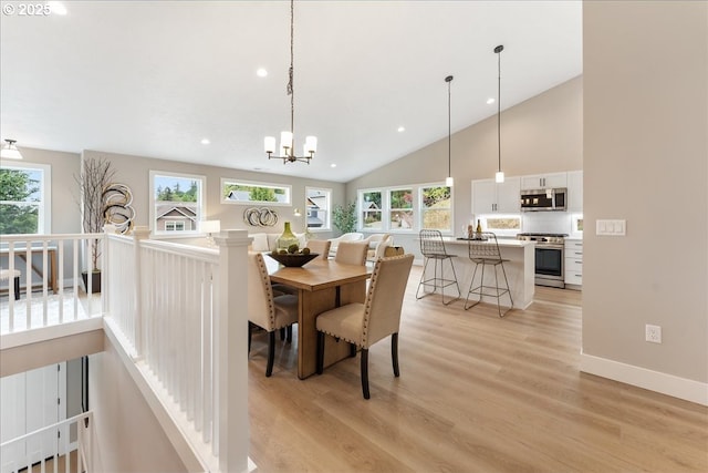 dining area with high vaulted ceiling, light hardwood / wood-style flooring, and a notable chandelier