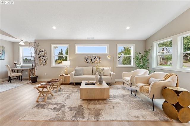 living room with vaulted ceiling and light hardwood / wood-style flooring