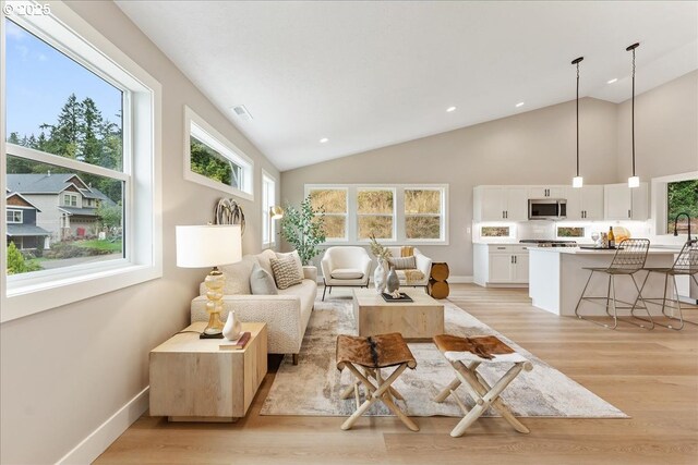 living room featuring high vaulted ceiling and light wood-type flooring