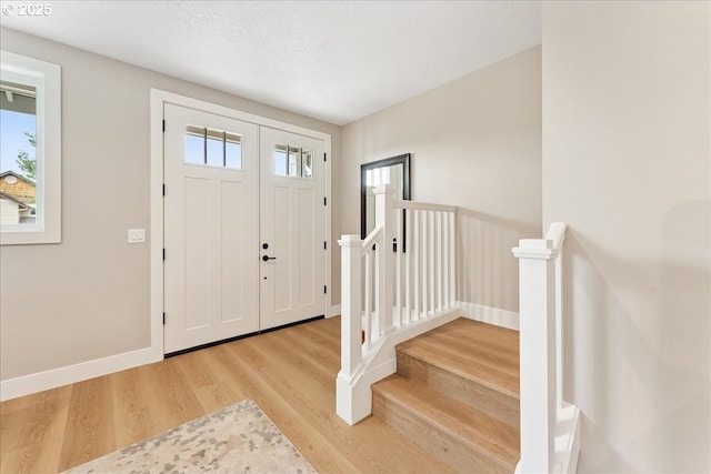 entryway with light hardwood / wood-style floors and a textured ceiling