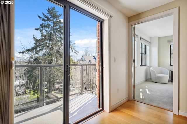 doorway to outside with wood finished floors and baseboards