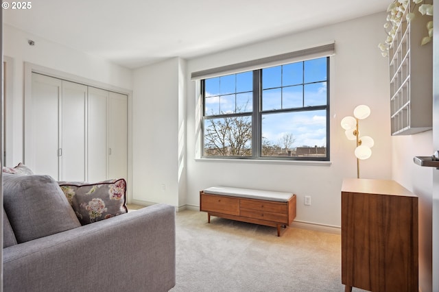 living area with light carpet and baseboards