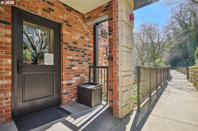 property entrance with a gate and brick siding