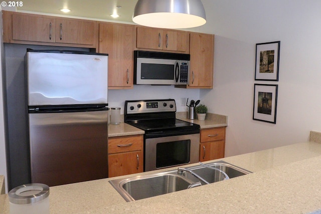 1125 NW 9th Ave, Portland, OR 97209 - kitchen with appliances with stainless steel finishes, light countertops, and brown cabinetry