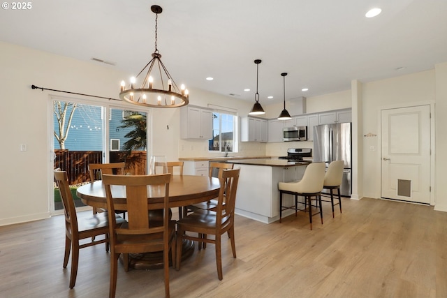 dining space featuring recessed lighting, visible vents, light wood finished floors, and a notable chandelier
