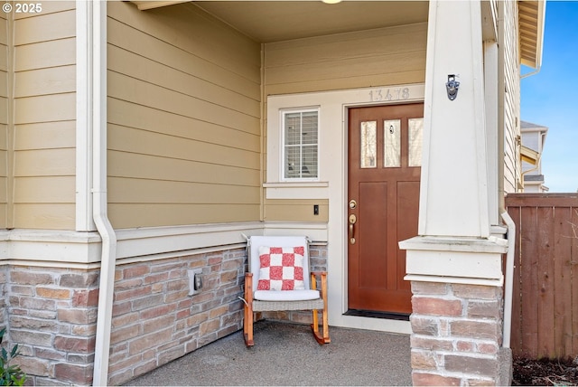 property entrance featuring fence and a porch
