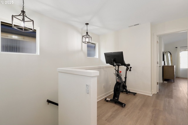 exercise room with visible vents, baseboards, and wood finished floors