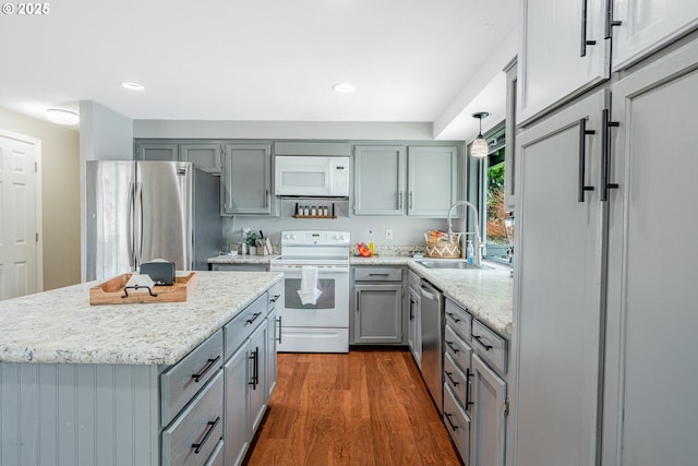 kitchen with dark wood-type flooring, gray cabinetry, a sink, recessed lighting, and appliances with stainless steel finishes