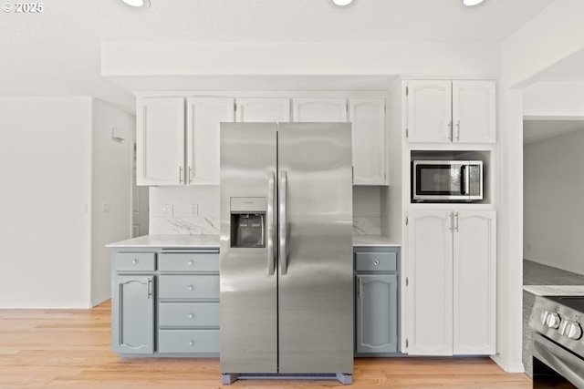 kitchen with white cabinetry, stainless steel appliances, recessed lighting, and light wood finished floors