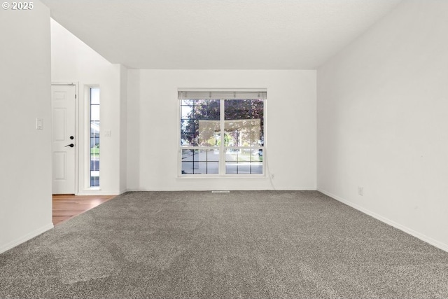 unfurnished room with carpet floors and baseboards