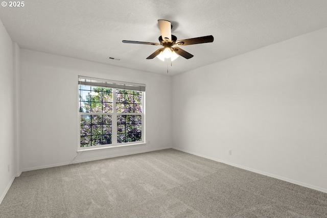 unfurnished room with visible vents, a ceiling fan, baseboards, and carpet floors