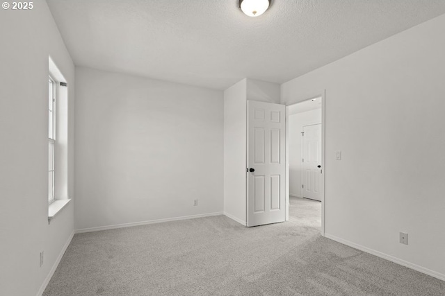 empty room with baseboards, a wealth of natural light, and carpet