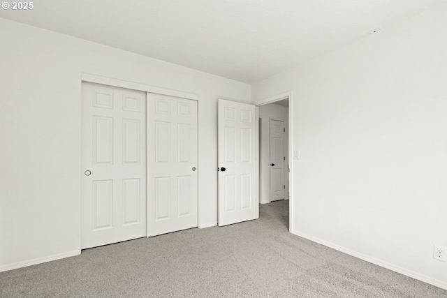 unfurnished bedroom featuring a closet, carpet flooring, and baseboards