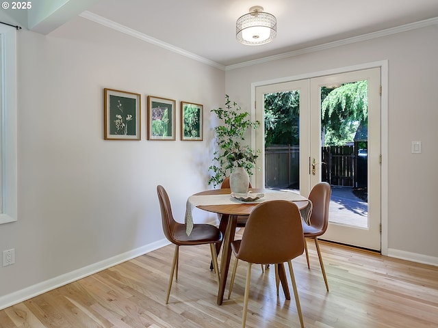 dining area featuring light wood finished floors, baseboards, french doors, and crown molding
