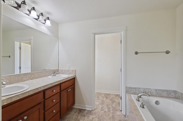 full bathroom with double vanity, a textured ceiling, a garden tub, and a sink