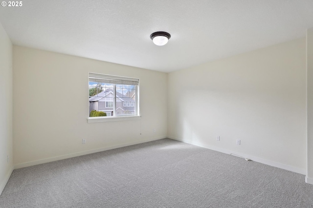 carpeted spare room with baseboards