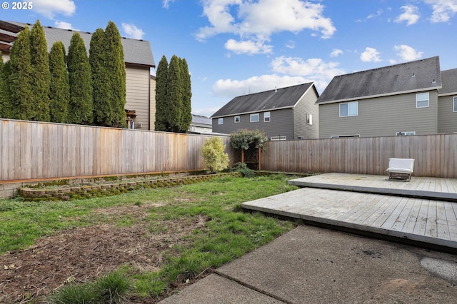 view of yard with a wooden deck, a residential view, and a fenced backyard