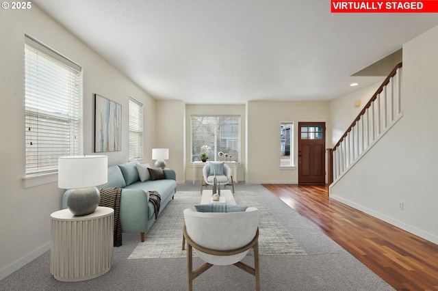 living room with stairs, wood finished floors, baseboards, and a wealth of natural light