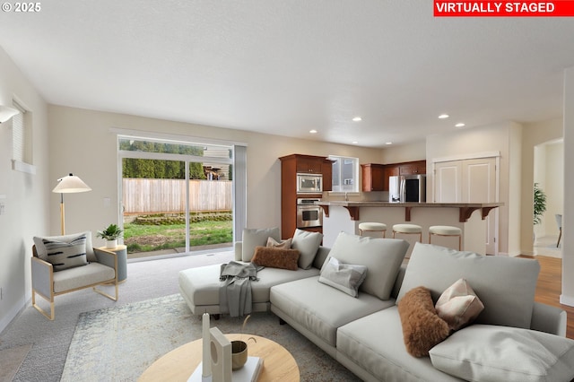 living room featuring recessed lighting, baseboards, and carpet floors