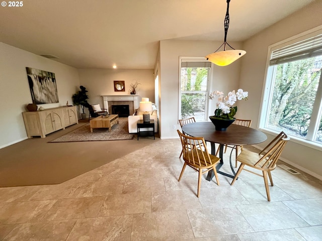 dining space featuring visible vents, baseboards, and a fireplace