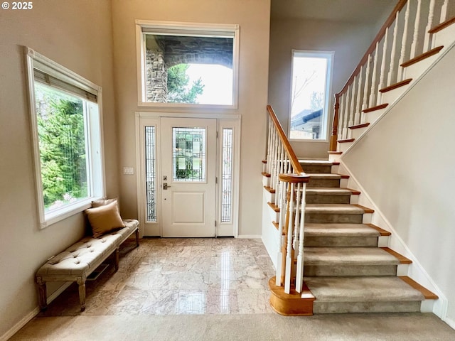 entrance foyer with stairs, baseboards, and marble finish floor