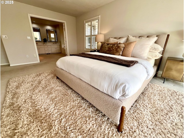 bedroom with connected bathroom, baseboards, and carpet floors