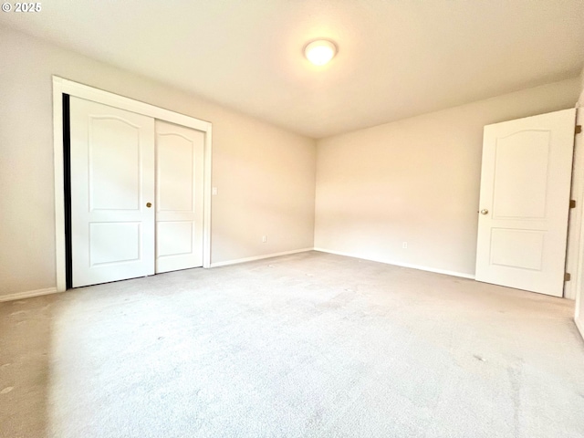 unfurnished bedroom featuring baseboards, a closet, and carpet floors