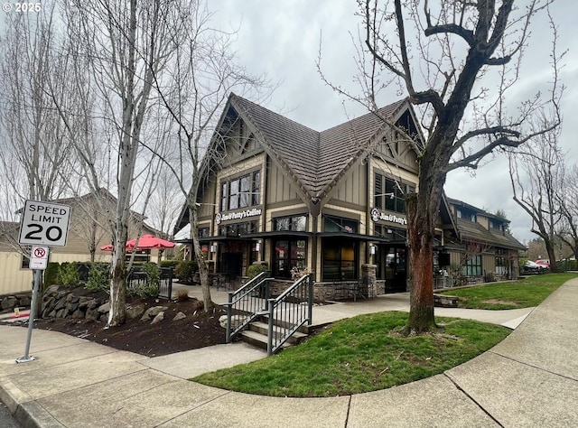 tudor-style house featuring stone siding and board and batten siding