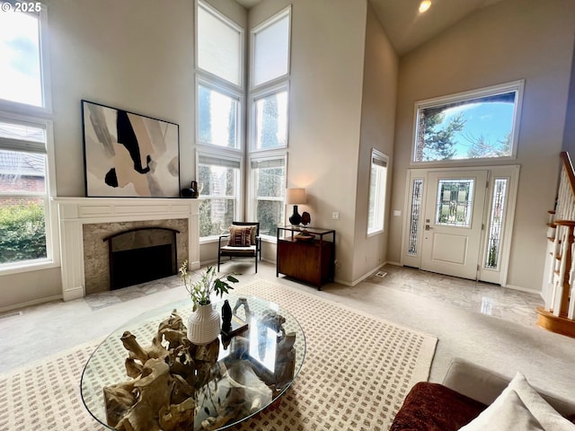 foyer entrance with high vaulted ceiling, a healthy amount of sunlight, and a fireplace