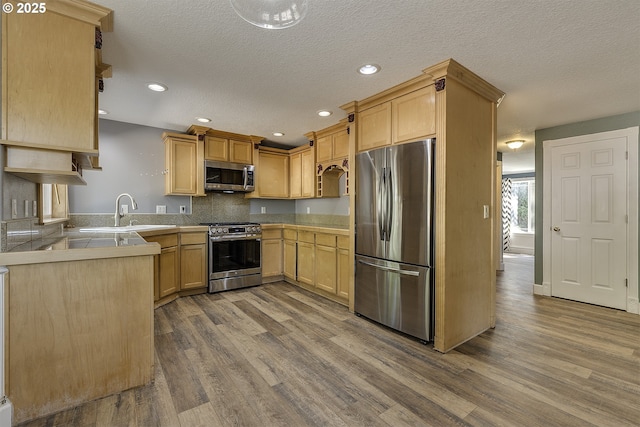 9373 SW Fast Pl, Portland, OR 97223 - kitchen with appliances with stainless steel finishes, dark wood finished floors, recessed lighting, light brown cabinets, and a textured ceiling